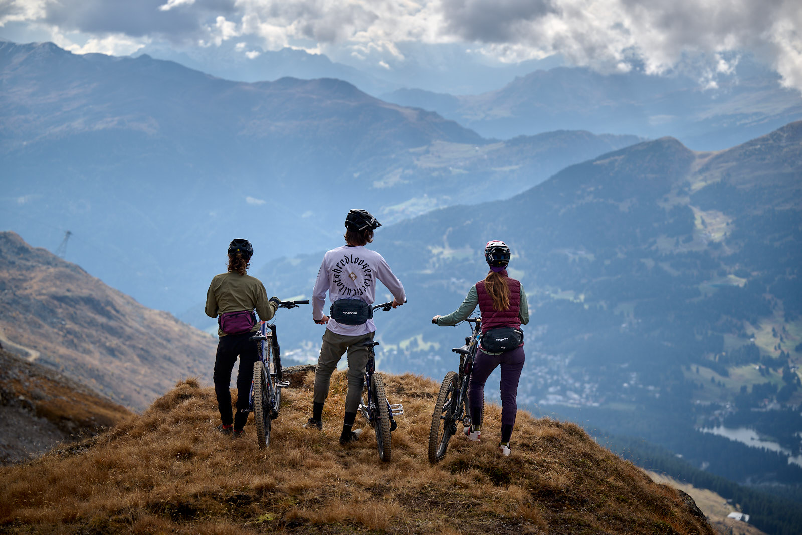 Drei Personen mit einer nach Maß gefertigten Bauchtasche stehen mit ihren Mountainbikes in den Bergen